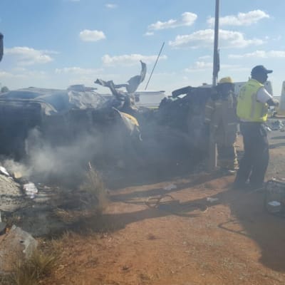 Rykande fordon, med räddningspersonal i mitten. 20 personer omkom i en olycka i Sydafrika, 19 av dem barn.