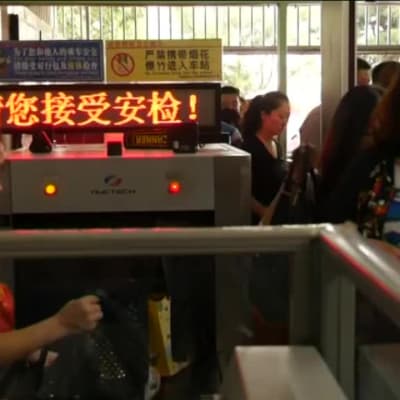 Metro-matkustajia läpivalaisussa Pekingissä.