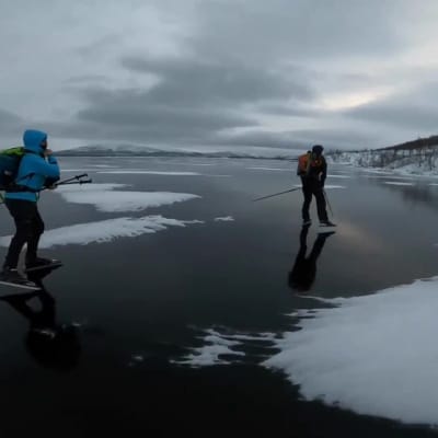 Retkiluistelijat kiitävät peilikirkkaalla Kilpisjärven jäällä