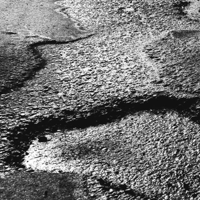 Bildcollage av en gropig asfaltväg och en tågräls.