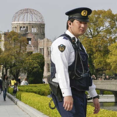 Japanilainen poliisi seisoskelee vartiossa Hiroshiman uhrien muistopuistossa 9. huhtikuuta.