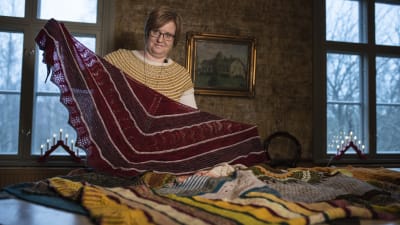 kvinna håller upp stickad sjal