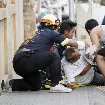 Sairaanhoitajat antoivat ensiapua pommi-iskussa loukkaantuneelle miehelle Hua Hinissä 12. elokuuta.