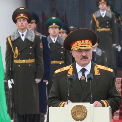 Aljaksandr Lukašenka pitää puhetta tummanvihreässä paraatiunivormussa koppalakki päässään. Taustalla näkyy sotilaita samankaltaisissa univormuissa.