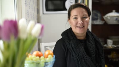 kvinna med frukt och blommor i förgrunden