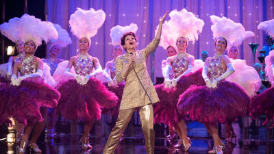 Judy Garland (Renée Zellweger står på scenen och sjunger, runtom en massa showgirls i fjäderkreationer.