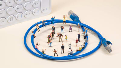 Leksaksfigurer uppställda i ring vid en internet-kabel.