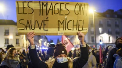Bilderna räddade Michel, står det på plakatet som en demonstrant höll upp över sitt huvud under en protest mot polisen.