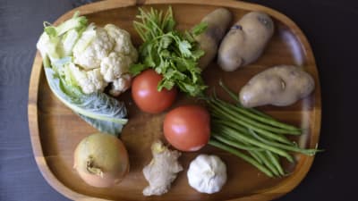 Blomkål, tomat, bönor, potatis, koriander, lök, ingefära och vitlök på ett fat