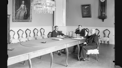 Interiör av Rådhusets sessionssal i Lovisa. Vid bordet sitter rådman Artur Wilhelmson, borgmästare Kuno Fredrik Nyman och rådman Axel Ringström.
