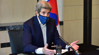USA:s klimatsändebud John Kerry på besök i Sydkorea. Han har ett blått muskydd på sig och talar i mikrofon. Bakom honom syns Sydkoreas flagga.