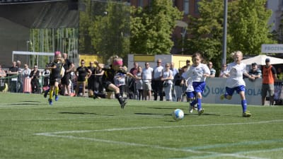 En av FC Komus spelare har nyss sparkat bollen mot målet på Vasa torg. På bilden är hon fångad i luften mitt i ett hopp