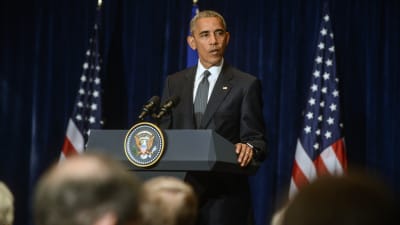 USA:s president Barack Obama bakom ett podium med USA:s och EU:s  flaggor i Bakgrunden. Obama fördömde dödsskjutningarna av poliser i Dallas under inledningen av Nato-toppmötet i Warszawa, Polen.
