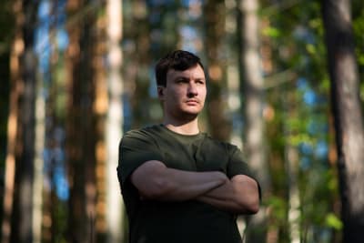 Logged in -dokumenttisarjan päähenkilö Aaron Soivio seisoo metsässä.