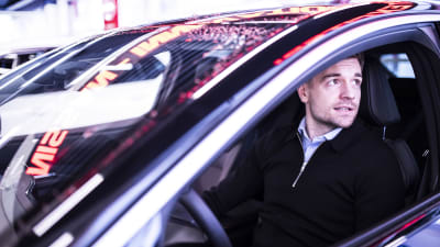 En ung man sitter i förarsätet av en bil