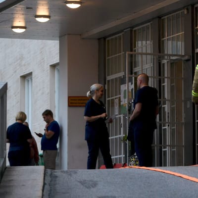 Palomies ja klinikan henkilökuntaa Naistenklinikan ulkopuolella Helsingissä 11. elokuuta 2019.