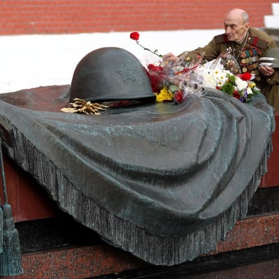 Sotaveteraani asettaa kukan Tuntemattoman sotilaan haudalle Moskovan Punaisella torilla.