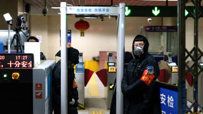 Vakter i Pekings metro tar temperaturen vid ingången till en station.