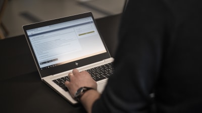 En person använder en bärbar dator och är inne på webbtjänsten Wilma.