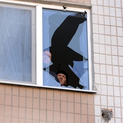 Kaksi miestä ikkunan ääressä Donetskissa.