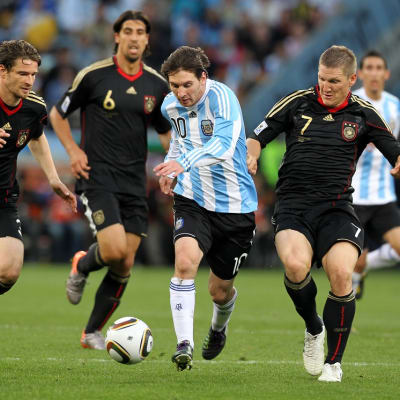 Saksan Arne Friedrich, Sami Khedira ja Bastian Schweinsteiger jahtaavat Lionel Messiä.