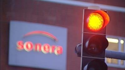 Soneras reklamskylt och ett trafikljus som visar rött
