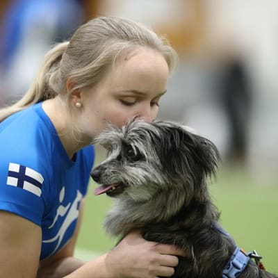 Joensuulainen agilitykilpailija Maria Hirvonen antaa suukon Miuxille, joka on pyreneittenpaimenkoira. 
