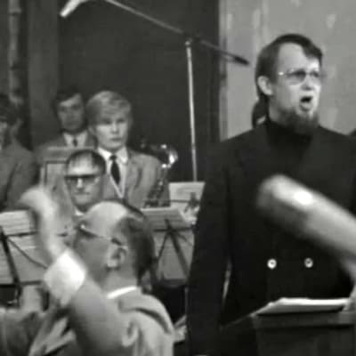 Kalle Holmberg johtaa Taistojen tiellä -laulun joukkoesitystä 1972