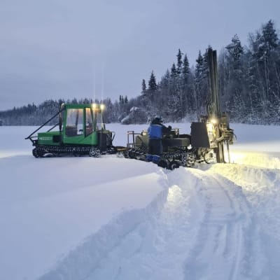 Mies ottaa moreeninäytteitä lumisessa maastossa Posion Maaninkavaarassa tammikuussa 2022. 