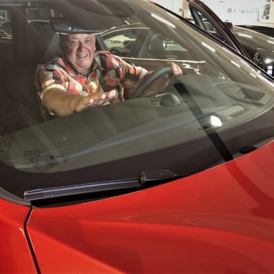 Alahärmäläinen Pentti Korpi istuu uudessa autossaan.