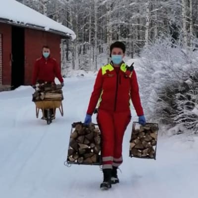 Eksoten ensihoitajat kantamassa puita iäkkäälle pariskunnalle kiireettömällä tehtävällä Etelä-Karjalassa