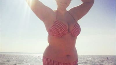 En kvinna i bikini på stranden.