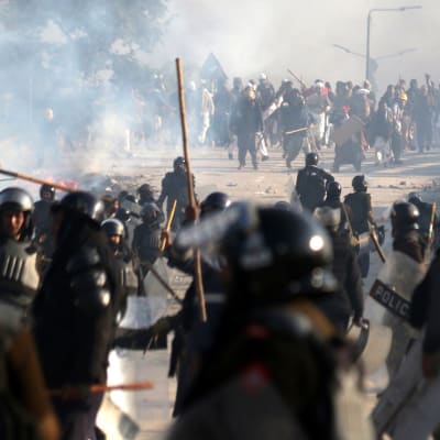 ett stort antal poliser utrustade med pålar drabbar samman med demonstranter i Islamabad, Pakistan.