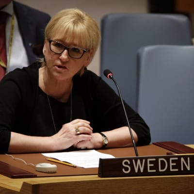 Margot Wallström pöydän ja mikrofonin takana, edessä kyltti, jossa lukee "Sweden". 