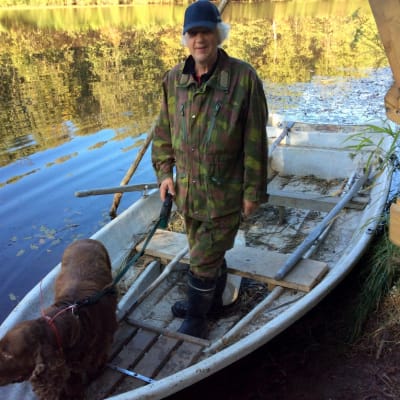 Aarne Tervo ja Sipe-koira veneessä Temmesjoella.