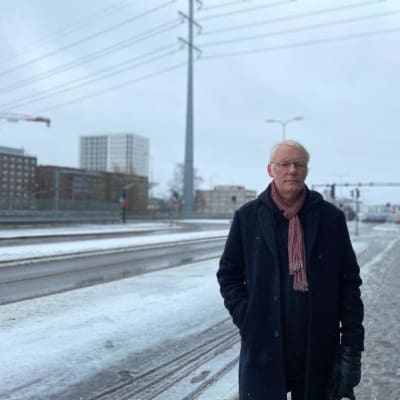 En allvarsam man står framför en korsning.