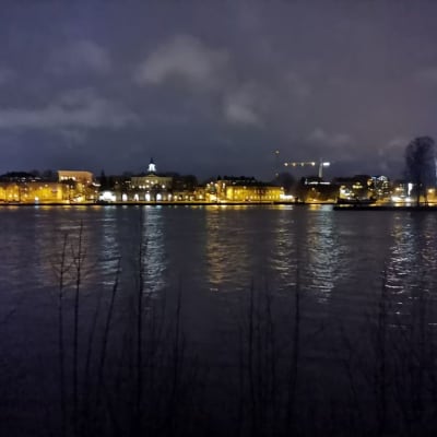 Porin kaupunki Kokemäenjoen yli katsottuna pimeänä joulukuun jälkipuoliskon iltana eli 18.12.2019.  Kuvassa näkyy Kivi-Poria, Raatihuone, Kirjurinluodon kärki.