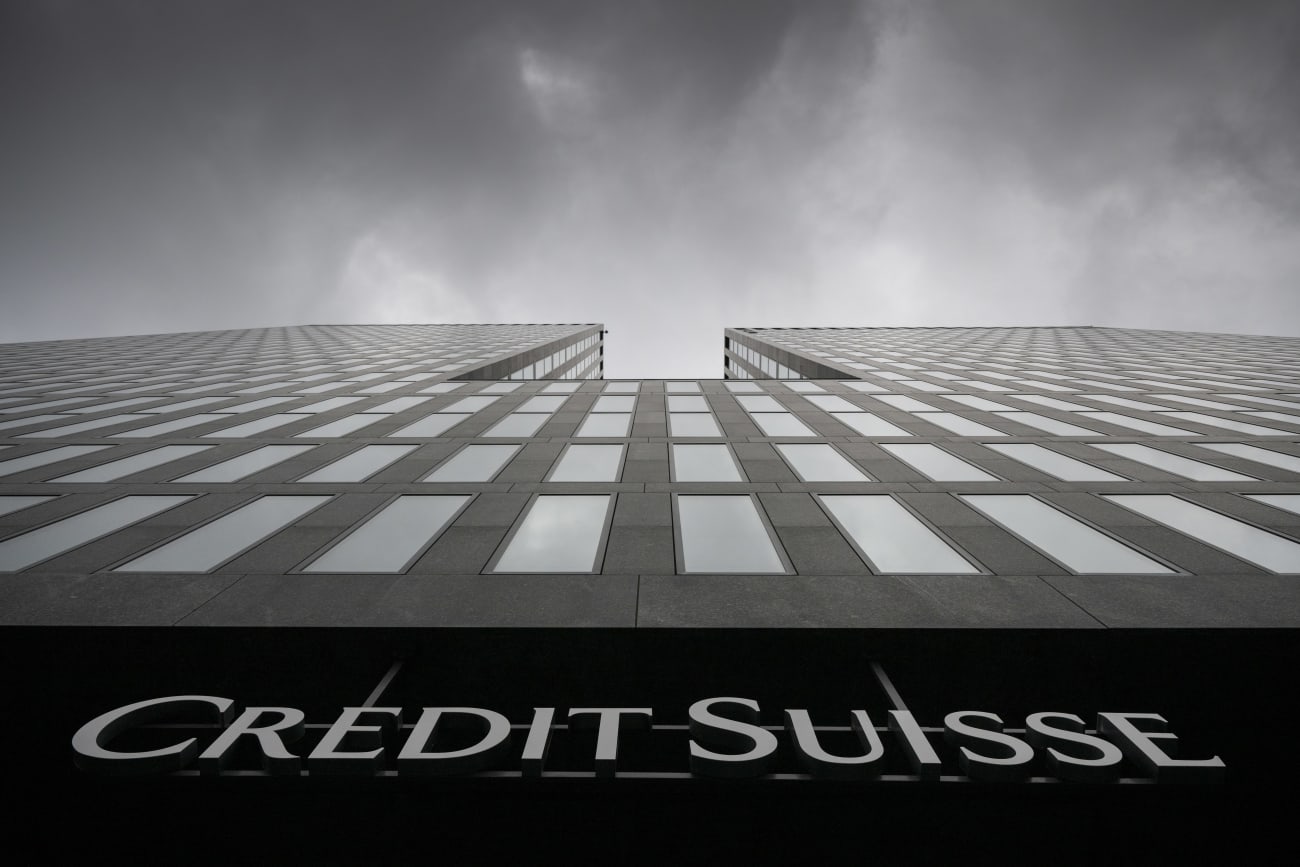 En bild av Credit Suisses gråa fasad tagen från marken med kameran riktad mot himlen. 