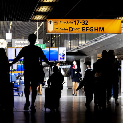 En mans siluett drar på reseväskor på flygplatsen .
