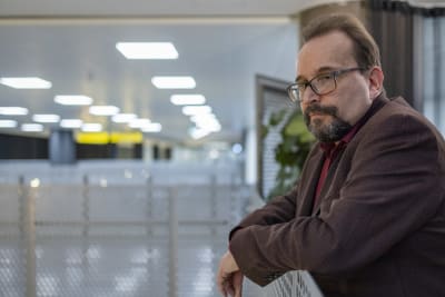 Migrationsverkets Olli Koskipirtti lutar sig mot ett räcke.