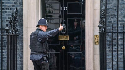 Poliskonstapel visar tummen upp utanför brittiska premiärministerns residens Downing Street 10.