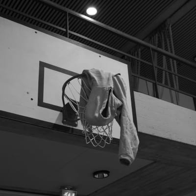 En huvtröja hänger från en basketring.