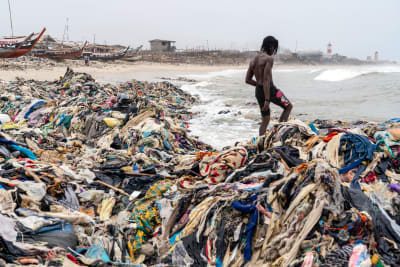 En stor mängd kläder som sköljts upp på en strand i Ghana.