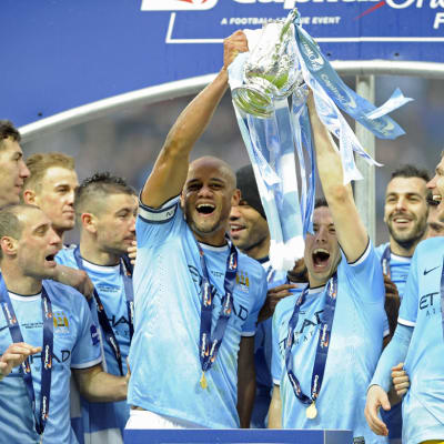 Manchester Cityn Vincent Kompany ja Samir Nasri nostavat liigacupin mestaruuspokaalin ilmaan.
