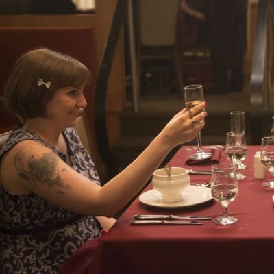 Girls-sarjan Hannah (Lena Dunham) istuu ravintolassa vanhempiensa kanssa.