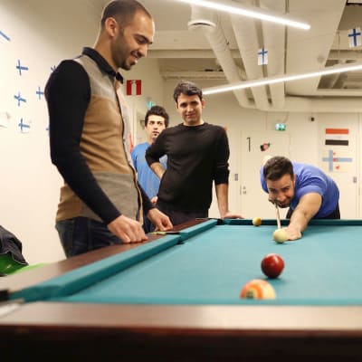 Mustafa Shakir pelaamassa biljardia muiden kanssa.