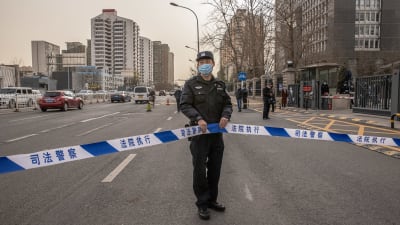 En polis står utanför en domstolsbyggnad i Kina