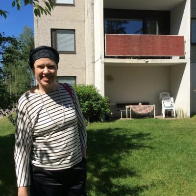 Maarit Feldt-Ranta står leende utanför sitt hemhus i Tallmo i Karis.