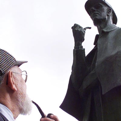 New Yorkin Sherlock Holmes-seuran jäsen Jim Moran katselee Holmesia esittävää patsasta Lontoossa.