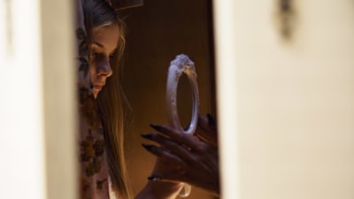 Huvudrollsinnehavaren Tinja ser sig i spegeln i den finska skräckfilmen Ruva.